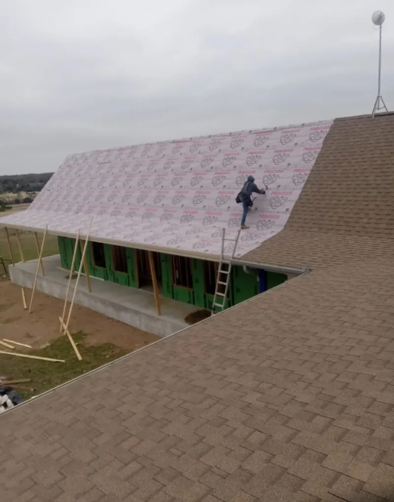 Worker preparing underlayment for a metal roof installation in Pinehurst